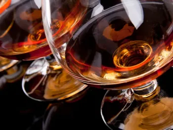Elegant glass of Cognac Lise Baccara reflecting golden amber hues, symbol of French craftsmanship